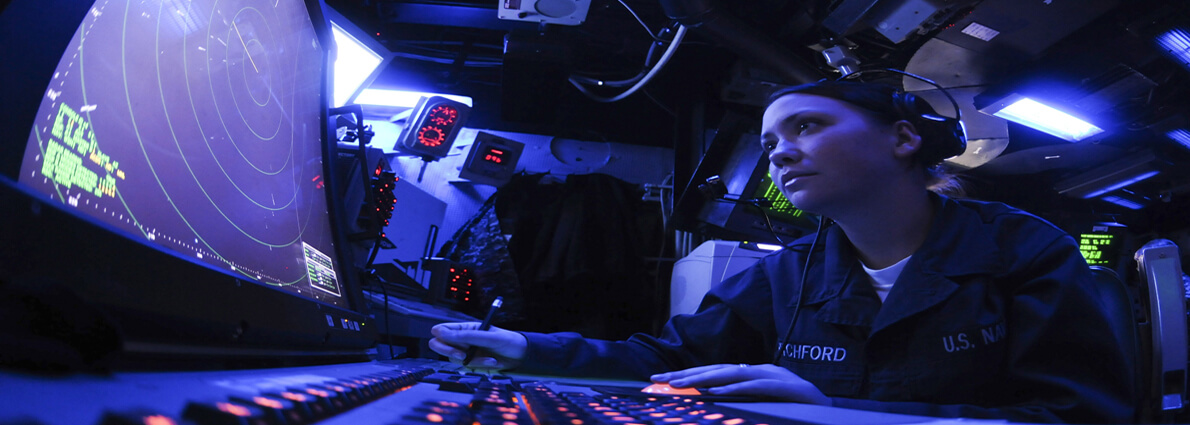 Military person at controls using data cables